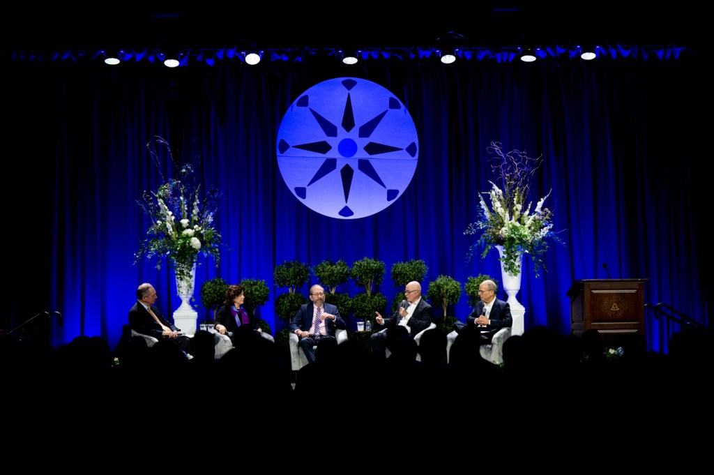 Speakers take part in a panel discussion at an education conference.